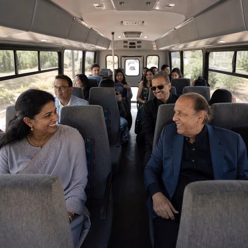 Group boarding a white charter bus for Private Event Transportation transportation in Anaheim