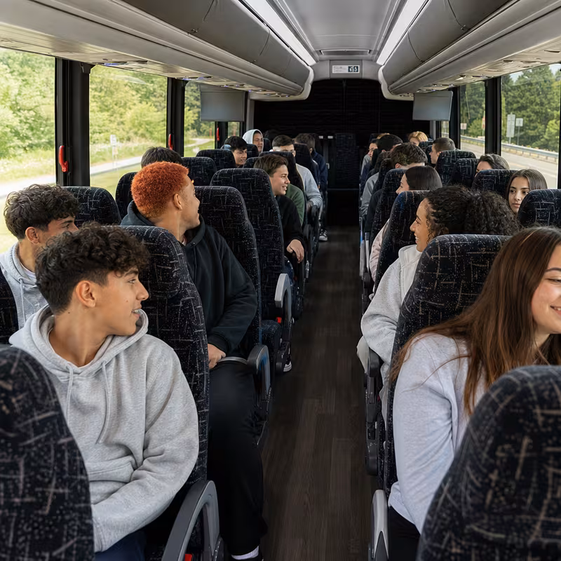 Group boarding a white charter bus for School Transportation transportation in Anaheim