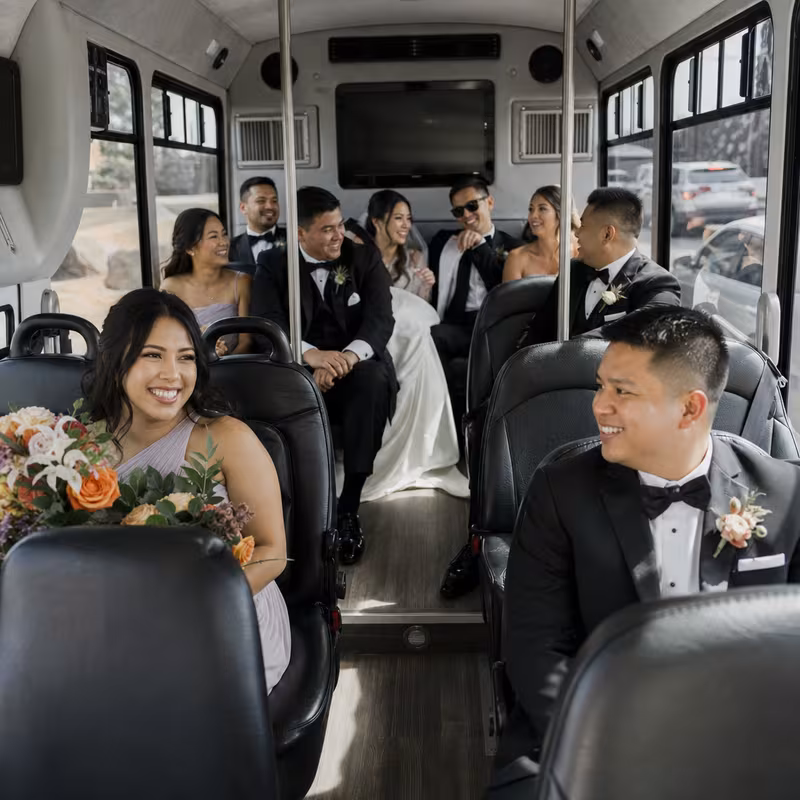 Group boarding a white charter bus for Wedding Transportation transportation in Anaheim